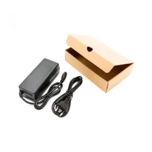Vista del pack completo del Cargador Patinete Eléctrico 54.6V 2A, con conector GX16 3 pines, caja de embalaje y cables robustos, compatible con SmartGyro.