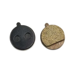 Vista lateral de las pastillas de freno redondas con pestaña para Patinete Eléctrico, modelo 006 de resina, mostrando el anclaje superior compatible con pinzas tipo JAK y Promax.